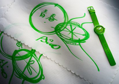 Green watch next to drawings