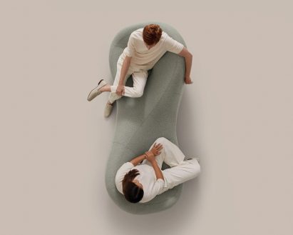 Overhead shot of two people sitting on a grey tete-a-tete bench
