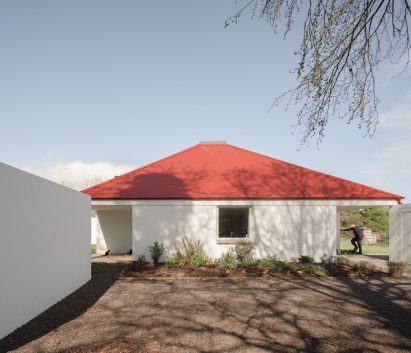 Exterior view of home with red roof by A2 Architects