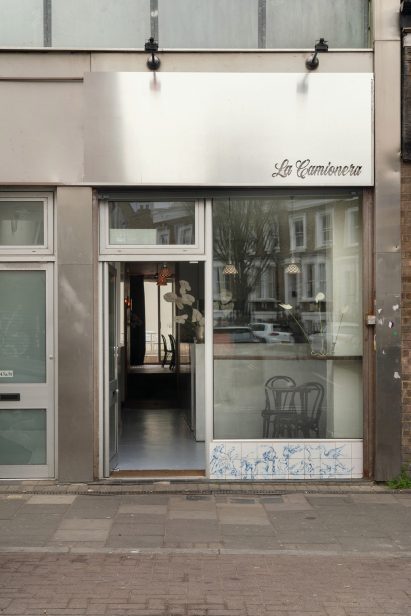 Facade of bar with metal panel, windows and painted tiles