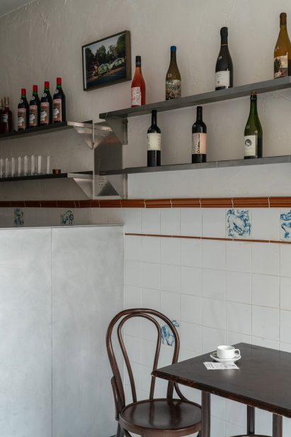 Bar interior with aluminium bar, metal shelving and cafe seating