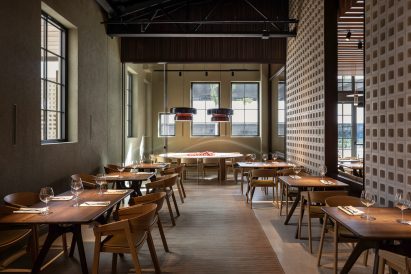 Dining area in an industrial-style building with blockwork partitions on the right side