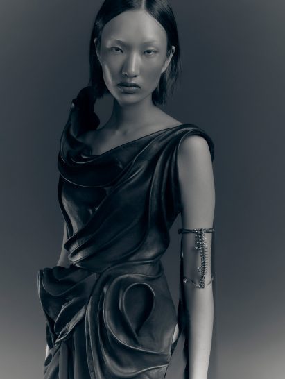 a photograph of a person wearing a grey garment against a grey backdrop