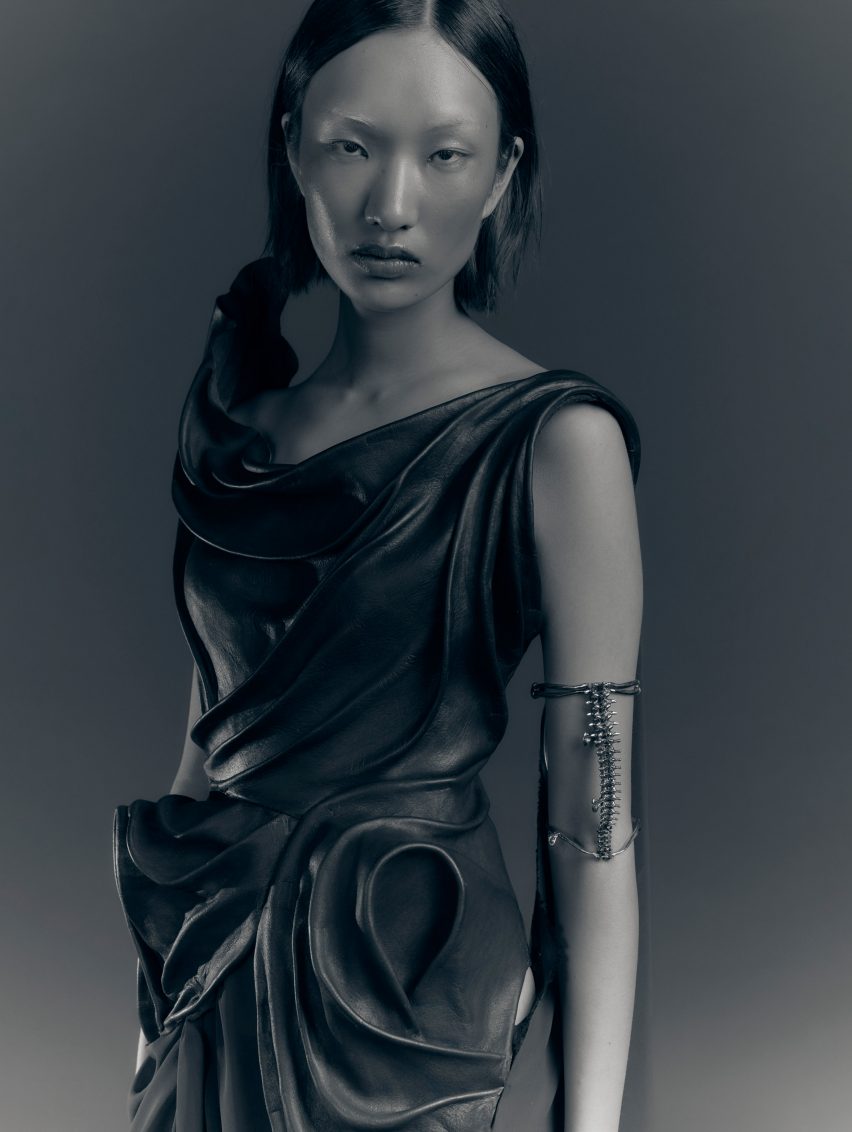 a photograph of a person wearing a grey garment against a grey backdrop