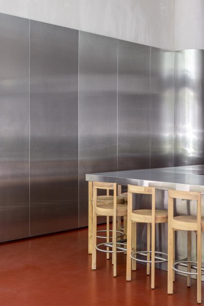 Circular solid-oak bar stools featuring stainless steel footrests