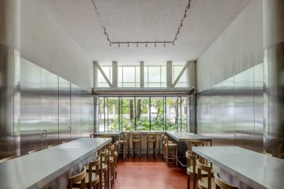Restaurant with pivoting, folding glass panels along the facade