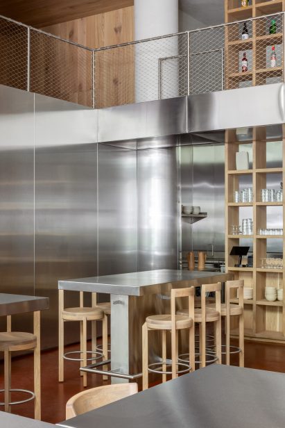 Restaurant interior with stainless steel panels wrapping the lower two-thirds