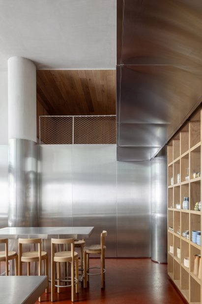Steel panels covering walls and columns, as well as communal tables