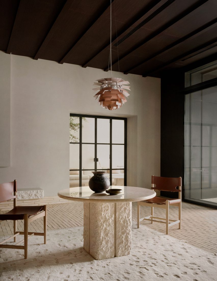 Stone and marble table with amber pendant light hanging above