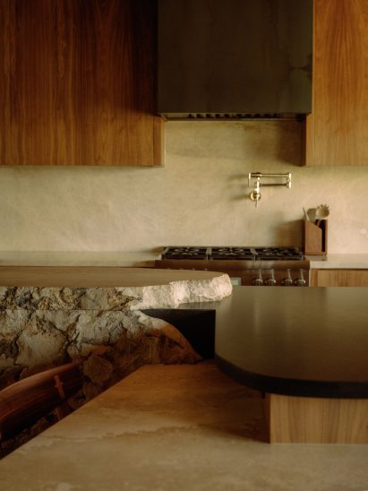 Kitchen island and table extending from a rough chunk of natural rock