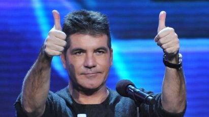 Simon Cowell holding two thumbs up