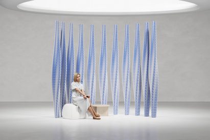 Woman sitting in from of 3D-printed wall partitions