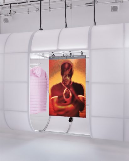 Video screens and apparel displayed in a pod suspended from the ceiling