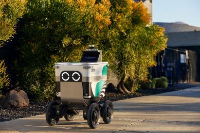 Photo of a Serve Robot with its big cute Wall-E eyes pootering along a pavement on its own