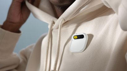 Photo showing a white Humane AI pin pinned to the front of a person's hoodie