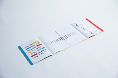 a photograph of an open book with white pages and text in tones of blue, yellow, red and black
