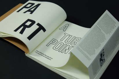 a photograph of an open book with white pages and black text on it