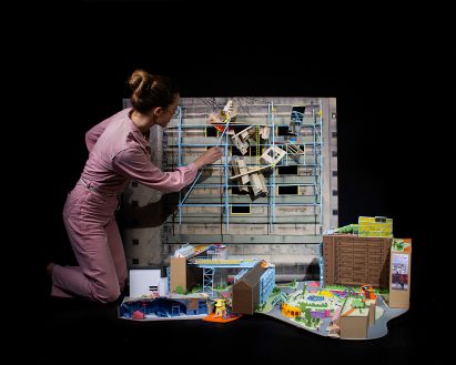 a photograph of a person tending to an architectural model