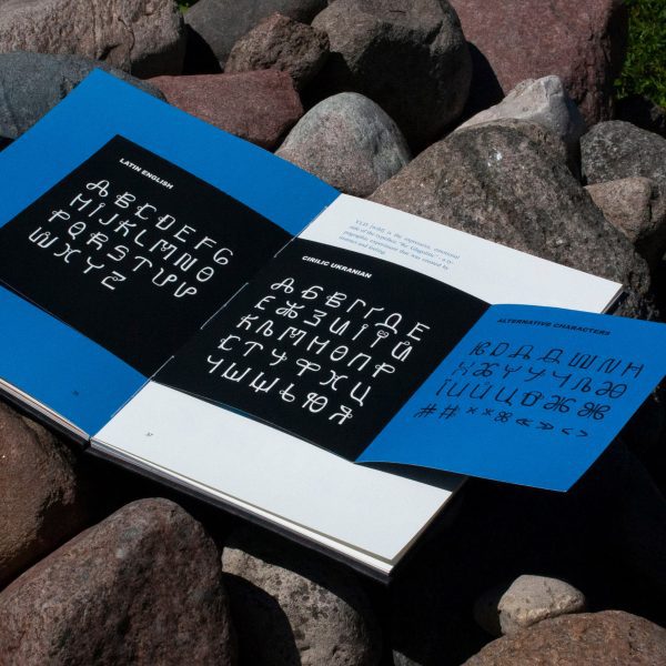 a photograph of a book in tones of blue, white and black, displaying a typeface design