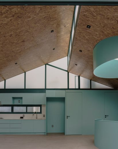 Teal kitchen below an OSB ceiling