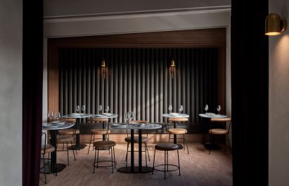 Small dining room in restaurant with gold sconce lights on wall