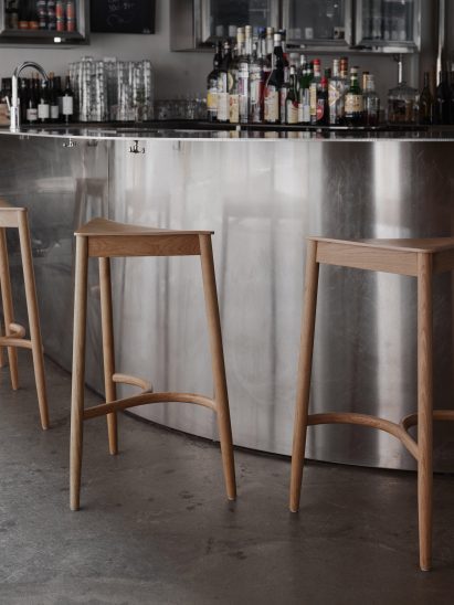 Wooden stools in front of a stainless steel bar