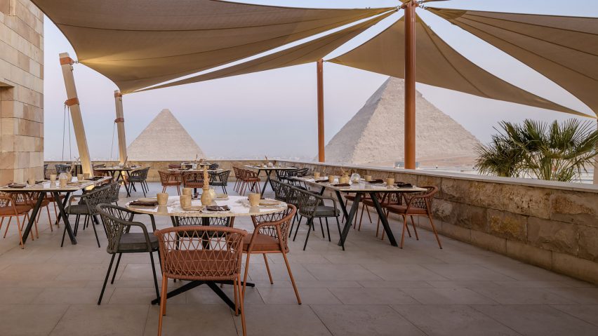 Outdoor terrace with pyramids in the background