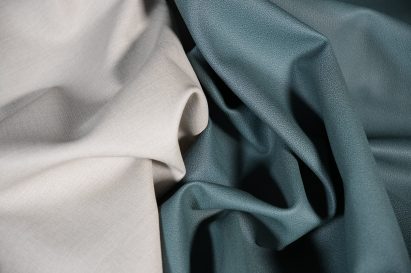 Photo of Hyphyn vinyl in two colours - a light grey on the left and a teal green on the right, crumpled together and meeting in the middle