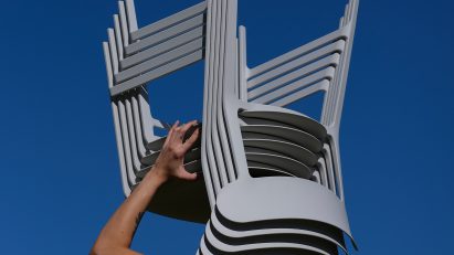 Person holding up a silver-looking chair