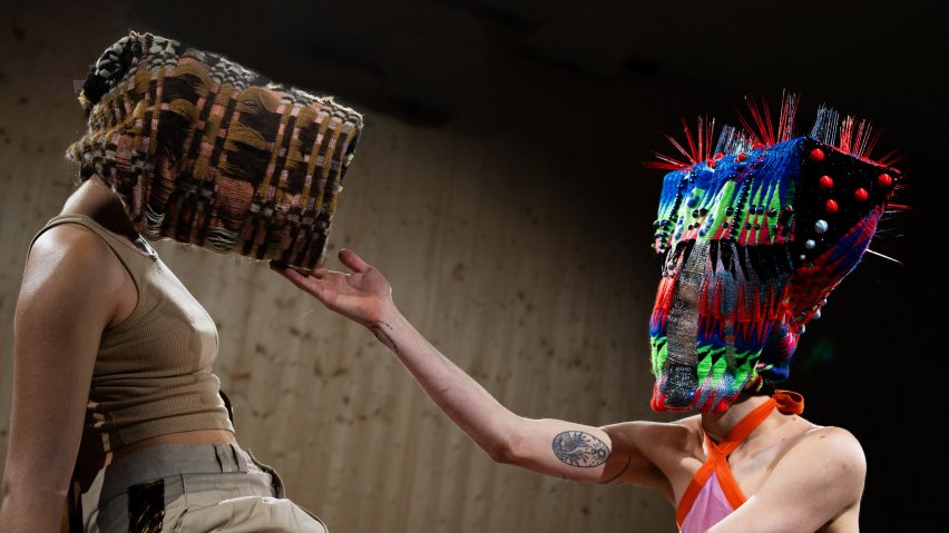 a photograph of two people wearing large head masks and facing one another