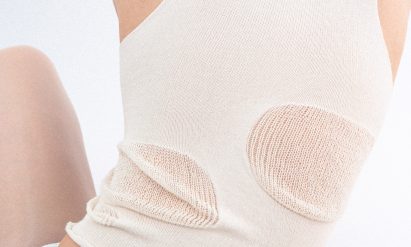 a cropped photograph of a person wearing a white knitted garment