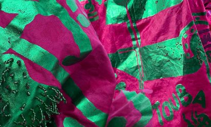 a photograph of a sheet of fabric in tones of green and pink