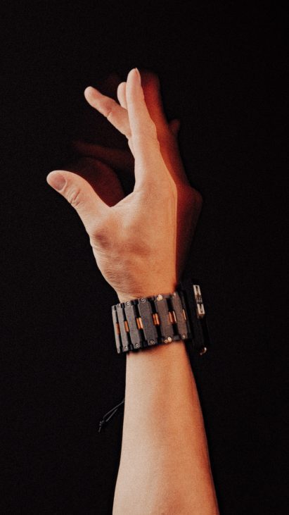 Photo of a person's hand wearing a prototype wrist wearable as they flick their fingers in the air