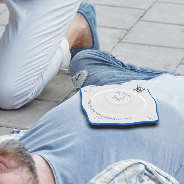 Person laying on pavement with diamond-shaped plastic apparatus on their chest
