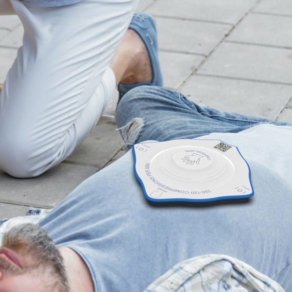 Person laying on pavement with diamond-shaped plastic apparatus on their chest
