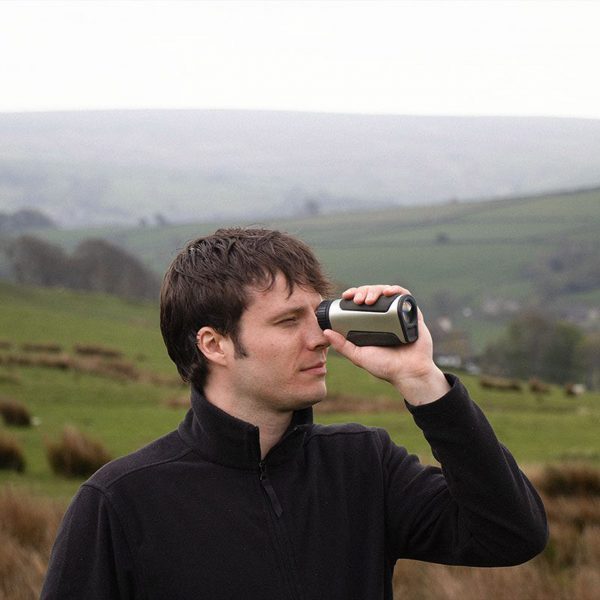 a photograph of a person holding a device up to their eye