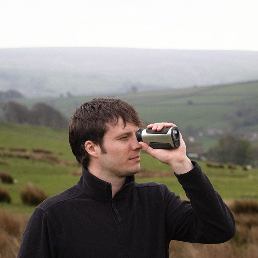 a photograph of a person holding a device up to their eye