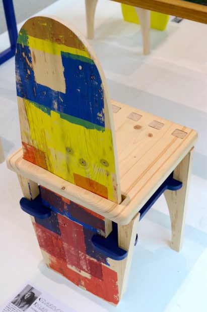 a photograph of a wooden chair with yellow, blue and red paint on it