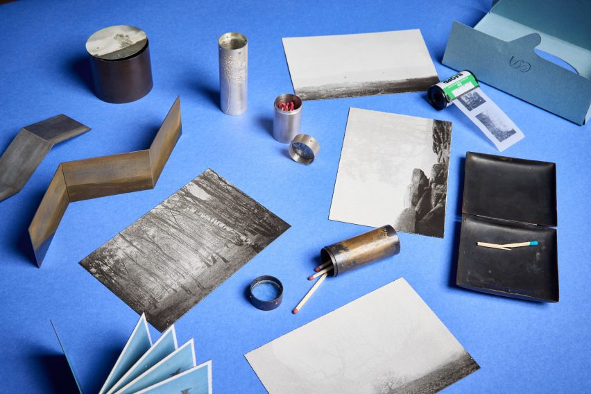 a photograph of printed images and matchsticks laid out on a blue backdorp