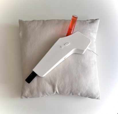 a photograph of a white device placed on a white cushion