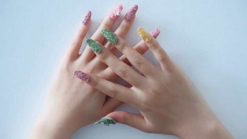 a photograph of a person's hands wearing press on nails