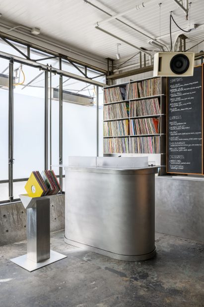A collection of vinyl records and chalkboards that display the restaurant's menu