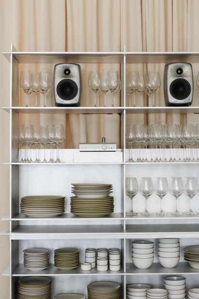 Open shelves displaying tableware and speakers