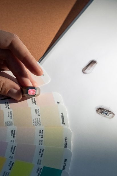 Hand holding a ring up to a colour chart
