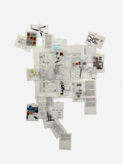 A series of papers taped to a plain backdrop