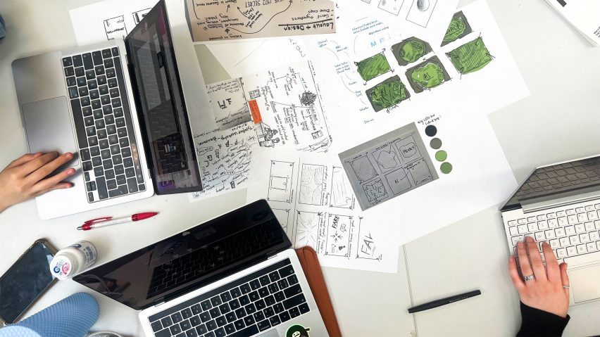 a photograph of a desk with paper and laptops on it