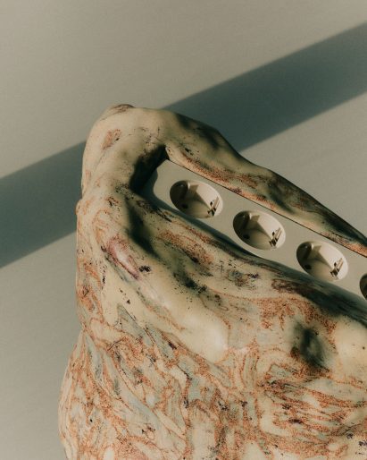 Close-up of ceramic sculpture with plugs at the centre