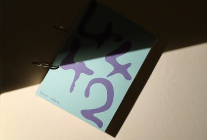 Photo of the front cover of the 4,4,4&2 book showing a light blue plain cover with the numbers in large wobbly writing
