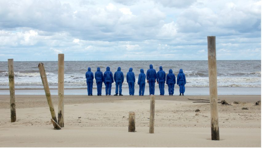 Photo of people in blue suits on a beach