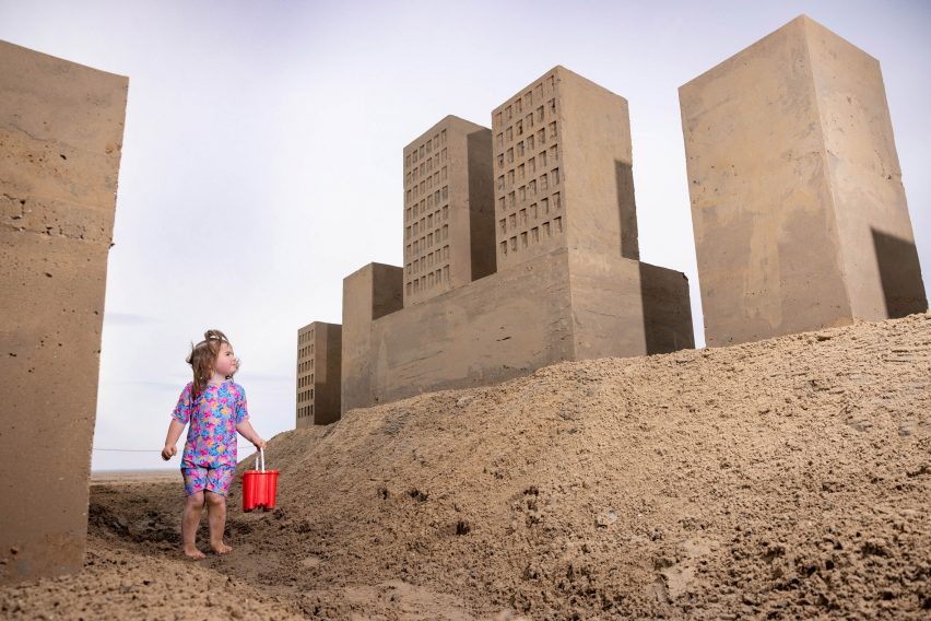 Girl looking at sand buildings